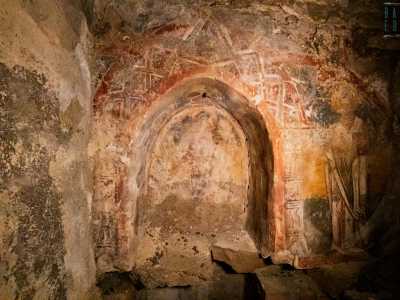 All�interno del piccolo arco sono presenti tre figure. Al centro � rappresentato Cristo su di un trono...
